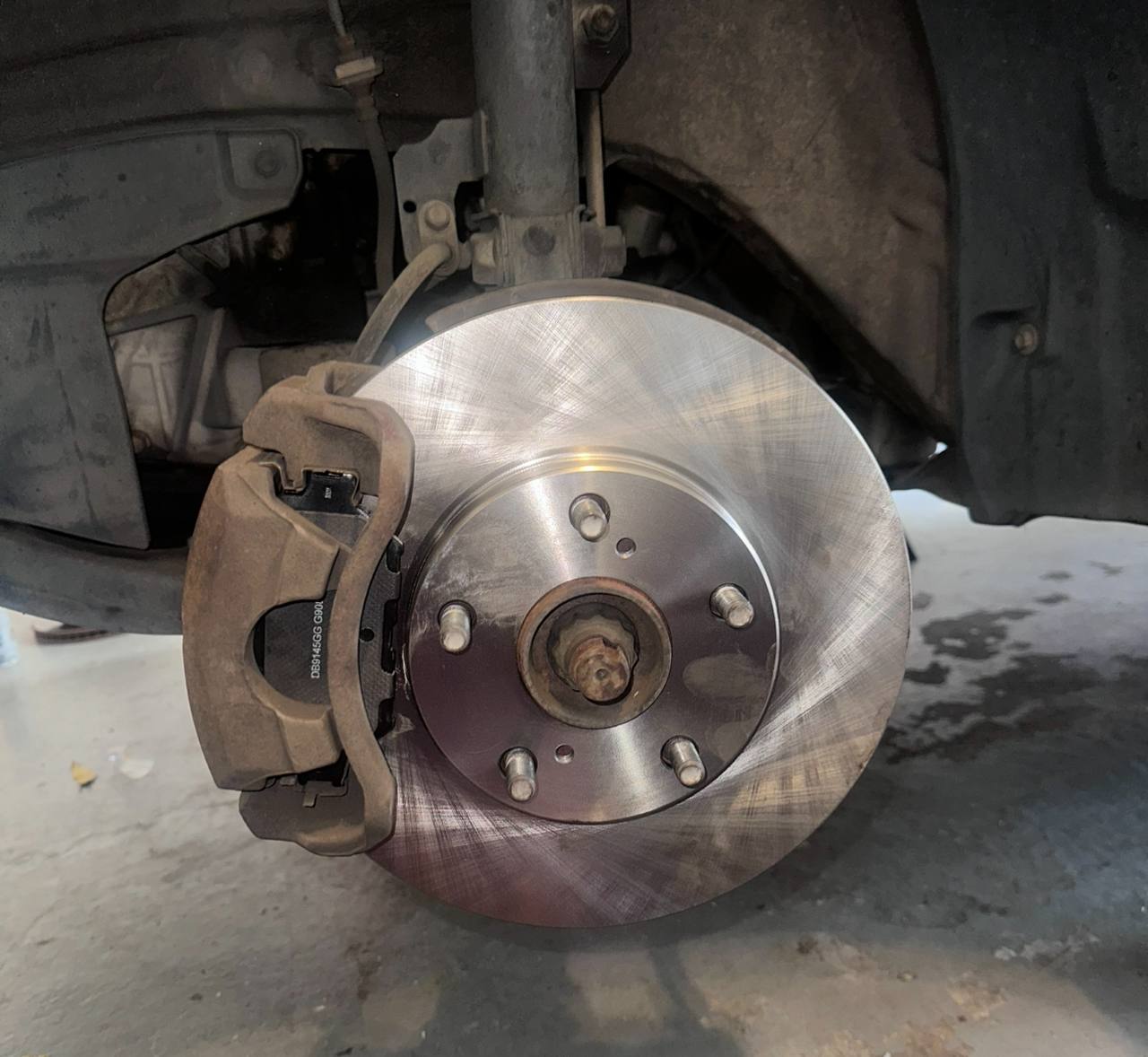 Freshly installed brake rotor and pads on a customer vehicle